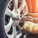 mechanic drilling car wheel